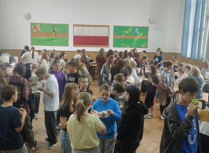 Uczniowie na jarmarku słodkości na auli.