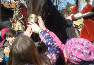 Uczniowie dotykają konia.