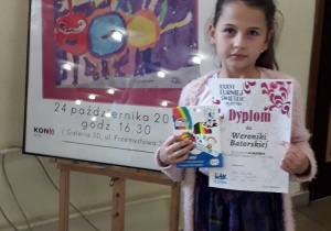 Dziewczynka prezentuje dyplom