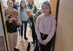 Dziewczynki stoją w drzwiach i przekładają buty