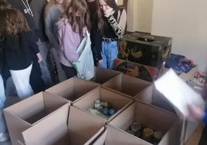 Uczennice i uczniowie pakują dary