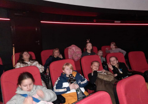 Dziewięć osób siedzi w kinie