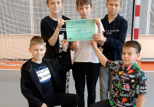 Pięciu chłopców stoi na sali gimnastycznej
