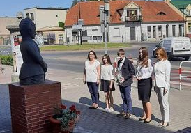 Pięć osób składa kwiaty pod pomnikiem Zofii Urbanowskiej