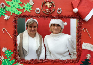 Dwie nauczycielki pozują w świątecznej fotobudce.