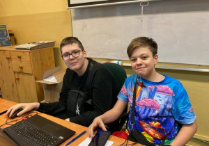 uczniowie siedzią przy komputerze