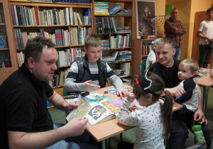 Cztery osoby siedzą przy stoliku w bibliotece