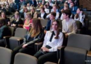 grupa uczniów siedzi w sali konferencyjnej