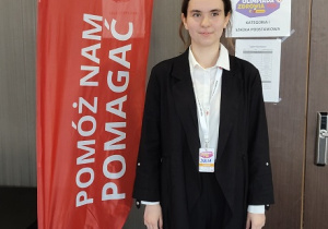 uczennica stoi przy banerze