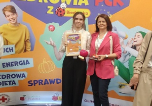 uczennica z nauczycielka stoi przy banerze