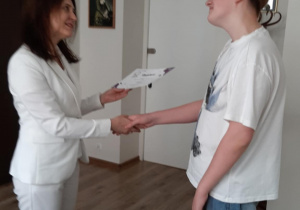 dyrektor wręcza uczniowi dyplom