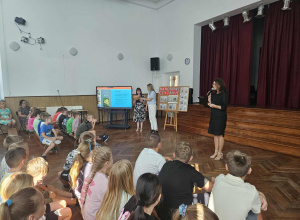 Dyrektor przemawia na auli do uczniów.