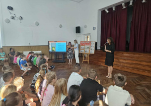 Dyrektor przemawia na auli do uczniów.