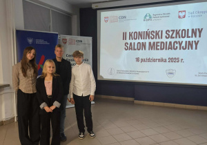 Czwórka uczniów stoi obok napisu "'II Koniński, szkolny salonik mediacji"