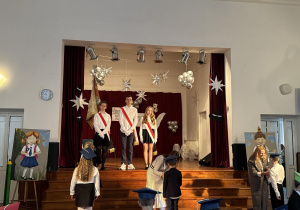 Uczniowie stoją ze sztandarem szkoły.