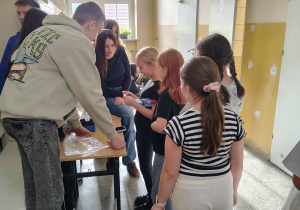 Uczniowie na korytarzu starają się odpowiedzieć na pytani dotyczące tabliczki mnożenia.