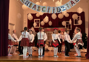 Uczniowie tańczą na scenie.