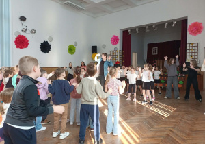 Dzieci tańczą z nauczycielem.