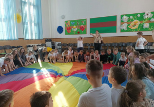 Dzieci siedzą przy chuście