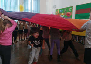 Dzieci przebiegają pod chustą.