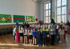 Dzieci stoją w kole wokół chusty.