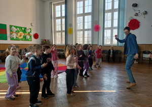 Nauczyciel pokazuje dzieciom taniec.
