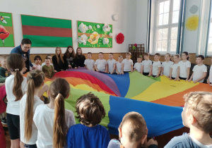 Dzieci bawią się przy chuście animacyjnej.