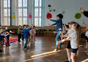 Dzieci tańczą wraz z nauczycielem.