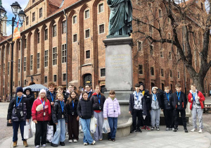 Dzieci stoją przy pomniku Kopernika.