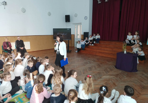 Nauczycielka wita gości na auli.