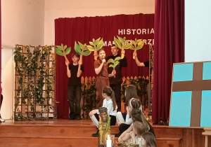 Dzieci grają drzewa na scenie.