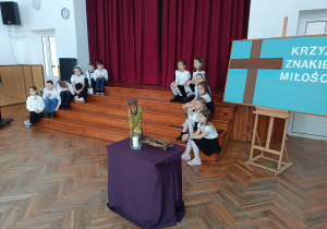 Uczniowie siedzą na schodach czekając na występ.